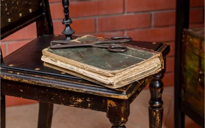 The Danger of Cut-and-Paste Christianity. Photo of ancient Bible with scissors on top.